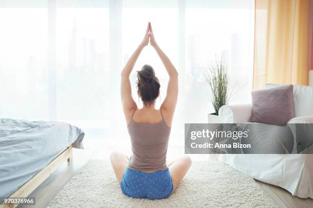 young woman stretching on floor of bedroom. debica, poland - anna bizon stock pictures, royalty-free photos & images