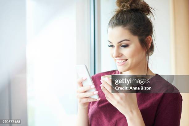 woman using mobile phone while drinking coffee. debica, poland - anna bizon stock pictures, royalty-free photos & images