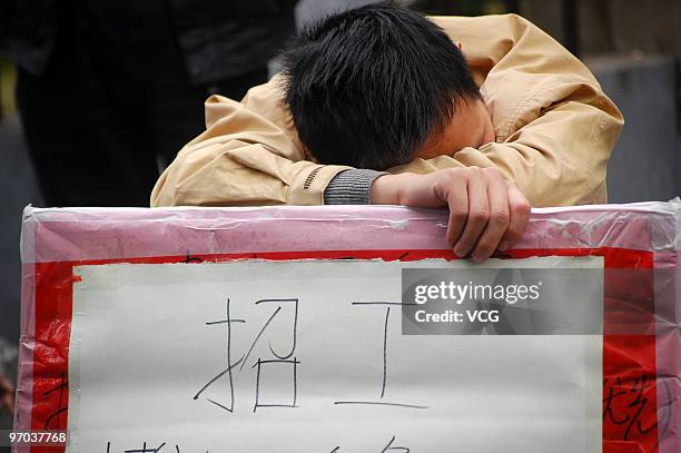 Recruiter naps on February 24, 2010 in Yiwu, Zhejiang province of China. Increasing employment opportunities in areas which traditionally exported...