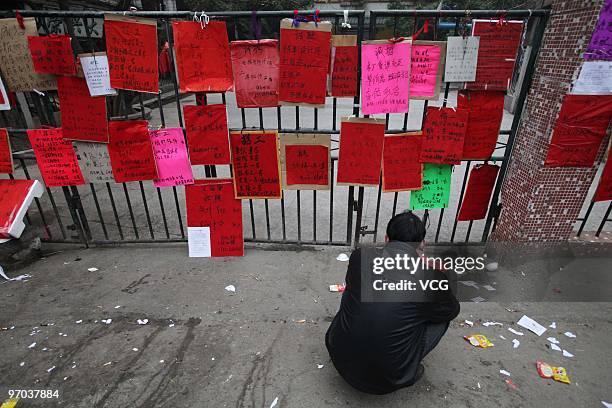 Man views the job information stuck on the gate of a Kindergarten on February 24, 2010 in Guangzhou, Guangdong province of China. Increasing...