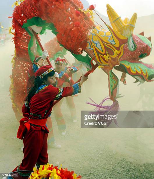 People perform dragon dance to greet the Lantern Festival on February 24, 2010 in Shiqian, Guizhou Province of China. The lantern festival marks the...
