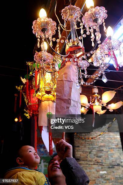 Man takes his baby viewing the illuminated lanterns to greet the Lantern Festival on February 24, 2010 in Hezhou, Guangxi Province of China. The...