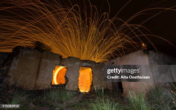 light painting in abandon house with spinning steel wool - witbank, south africa - burning steel wool firework stock pictures, royalty-free photos & images