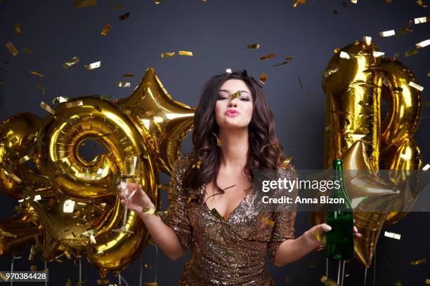 cheerful woman, pouting with champagne glass and bottle in hands. celebrating new year's eve. debica, poland - anna bizon stock pictures, royalty-free photos & images