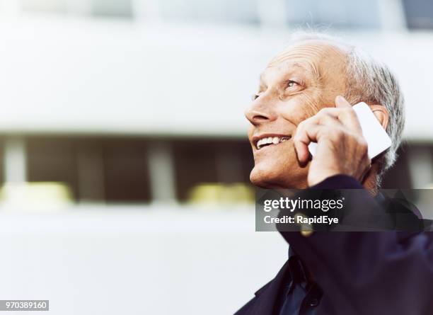 gelukkig zakenman op zijn mobiele telefoon buiten een kantoorgebouw - happy mobile stockfoto's en -beelden