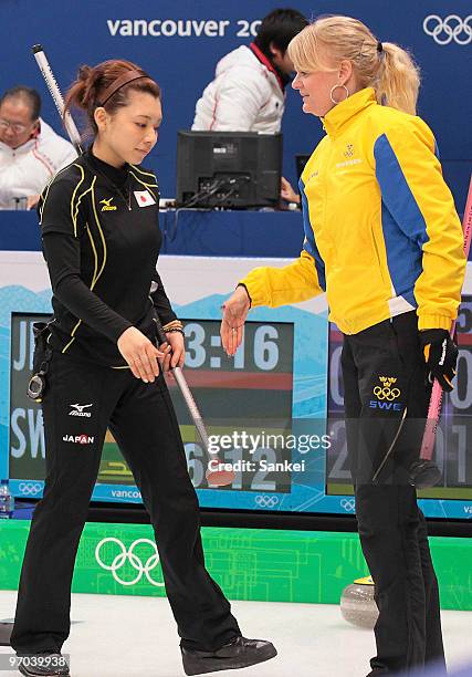 Moe Meguro of Japan and Anna Le Moine of Sweden shake hands after the women's curling round robin game between Japan and Sweden on day 12 of the...