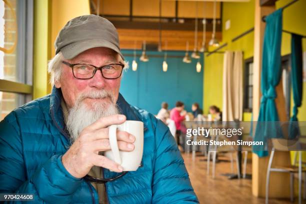 active senior enjoying coffee in cafe in montana - small town america stock-fotos und bilder