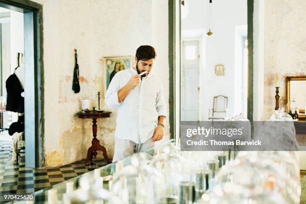 man sampling fragrances in perfumery - perfume photos et images de collection