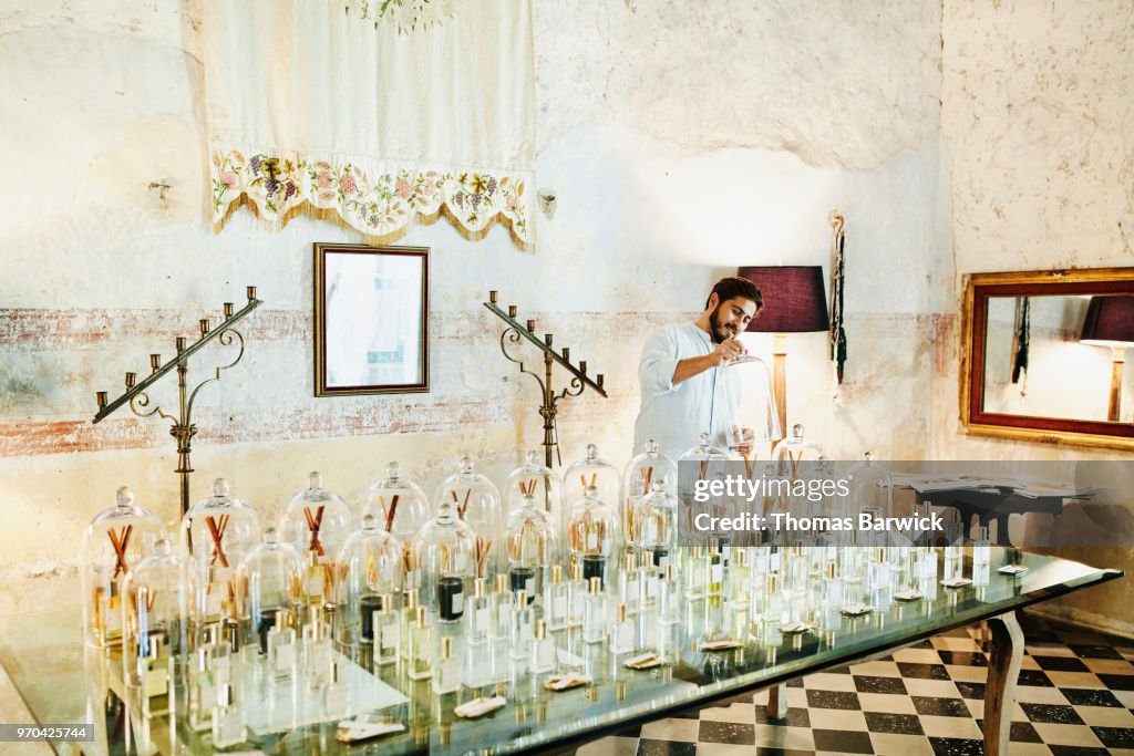 Smiling man sampling fragrances in boutique while shopping during vacation