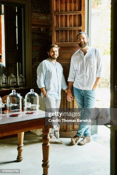 Portrait of smiling gay couple holding hands while shopping in boutique