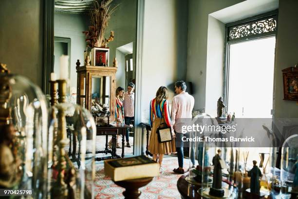 couple looking at historical artifacts while shopping in boutique during vacation - couple shopping stock pictures, royalty-free photos & images