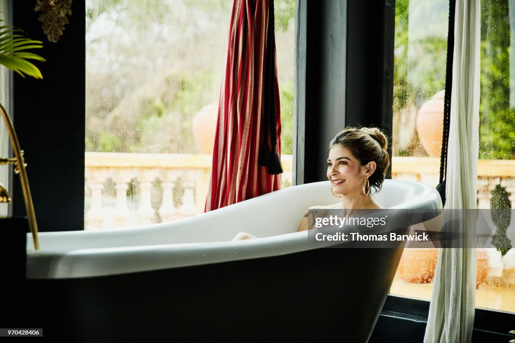 Smiling woman in bathtub in boutique hotel