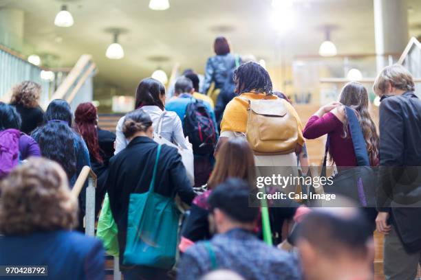 Crowd of people with backpacks and bags climbing stairs