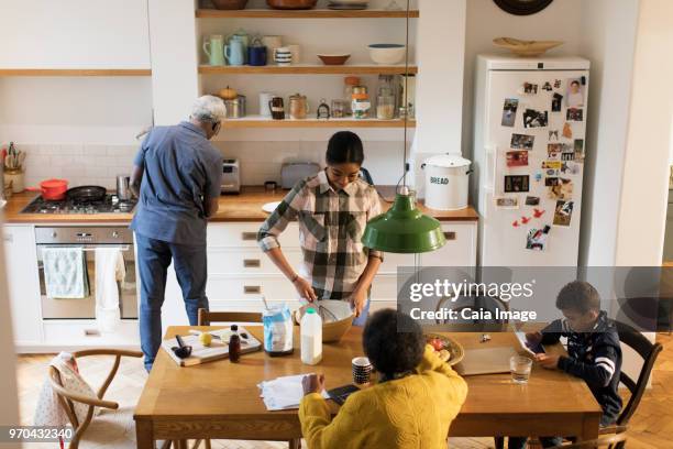grandparents and grandchildren baking and using digital tablet in kitchen - grandma invoice bildbanksfoton och bilder
