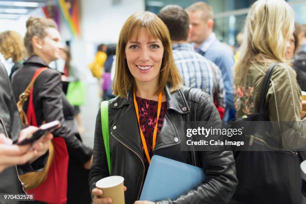 Portrait smiling, confident businesswoman drinking coffee at conference