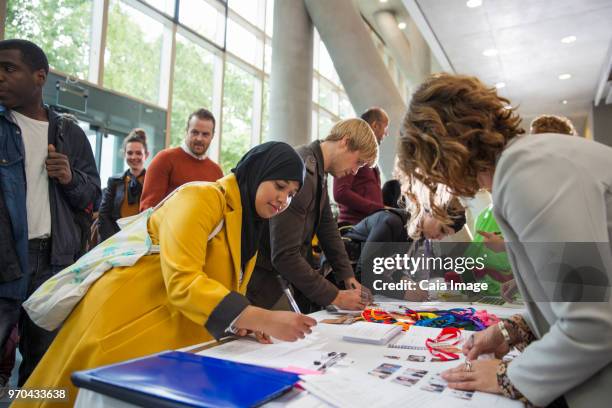 Businesswoman in hijab arriving, checking in at conference registration table