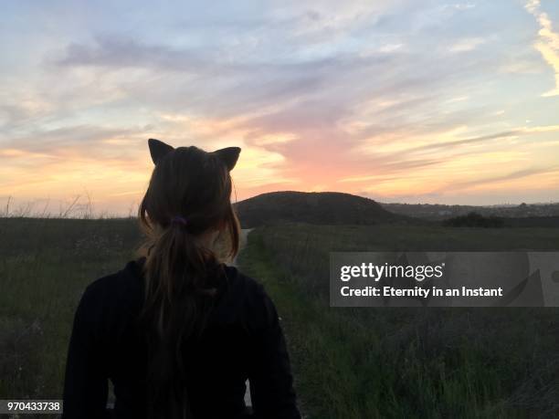 girl wearing cat ears looking at the horizon - costume cat ears fotografías e imágenes de stock