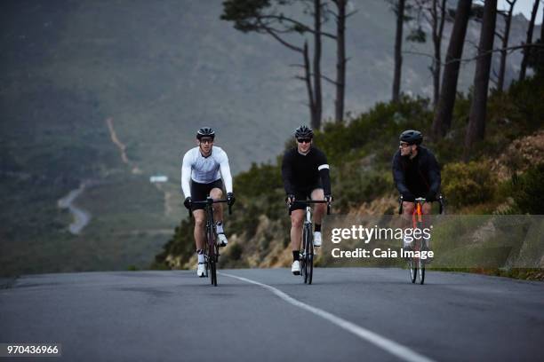 male cyclists cycling on road - radfahren männer stock-fotos und bilder