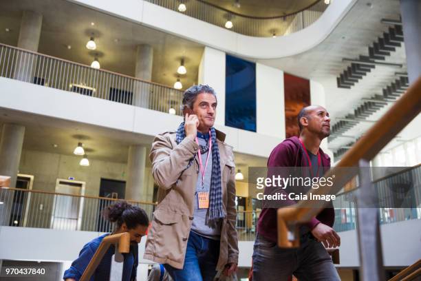 Businessman talking on cell phone, ascending office stairs