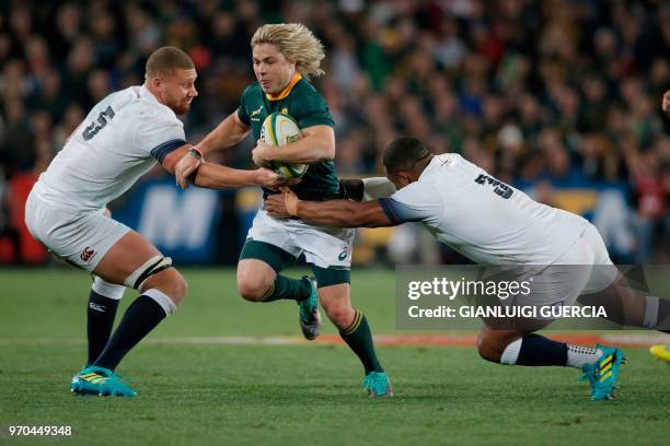 South Africa fly-half Faf de Klerk is tackled by England tight head prop Kyle Sinckler and lock Nick Isiekwe during the rugby union test match...