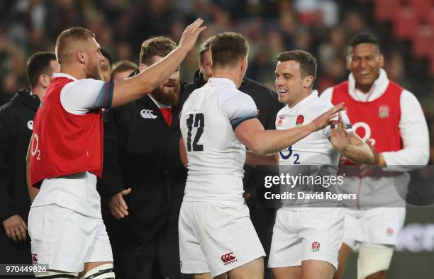 Owen Farrell of England celebrates with George Ford and team mates as he scores their third try during the first test between and South Africa and...