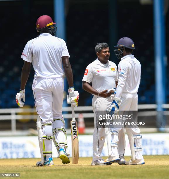 Rangana Herath and Niroshan Dickwella of Sri Lanka celebrate the dismissal of Jason Holder of West Indies during day 4 of the 1st Test between West...
