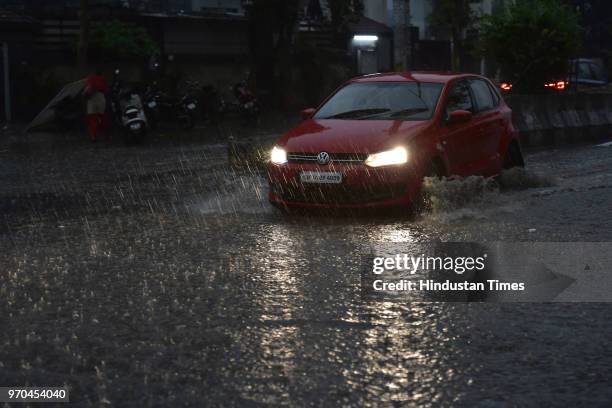 Vehicle move past through waterlogged roads during rain after heavy dust storm at sector 63, on June 9, 2018 in Noida, India. The dust storm pushed...