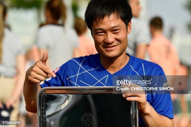 Japan's Shingo Kunieda poses with his trophy after winning the men's wheelchair singles final match against Argentina's Gustavo Fernandez, on day...