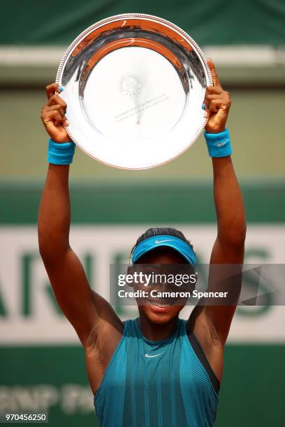 Cori Gauff of The United States celebrates victory with the trophy following the girls singles final against Caty McNally of The United States during...