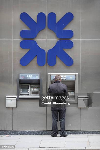 Customer uses an ATM outside the headquarters of the Royal Bank of Scotland in London, U.K., on Thursday, Feb. 25, 2010. Royal Bank of Scotland Group...