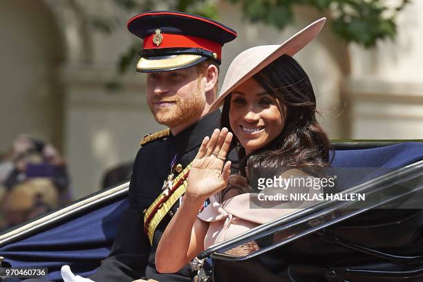 Britain's Prince Harry, Duke of Sussex and Britain's Meghan, Duchess of Sussex return in a horse-drawn carriage after attending the Queen's Birthday...