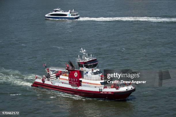 An FDNY boat patrols in the East River before the start of a group jet ski ride, June 9, 2018 in New York City. Hundreds of watersports enthusiasts...