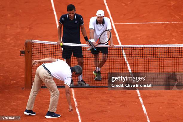 Mate Pavic of Croatia and Oliver Marach of Austria contest a line call during the mens doubles final against Pierre-Hugues Herbert of France and...