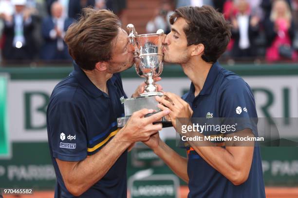 Pierre-Hugues Herbert of France and Nicolas Mahut of France kiss the trophy as they celebrate victory following the mens doubles final against Oliver...