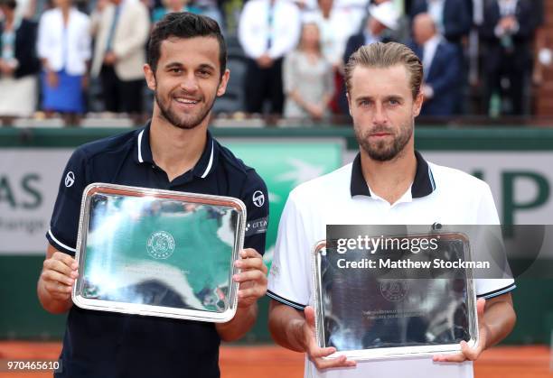 Mate Pavic of Croatia and Oliver Marach of Austria hold the runners up trophy following the mens doubles final against Pierre-Hugues Herbert of...