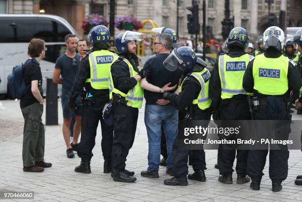Man is detained by police as supporters of Tommy Robinson protest in Trafalgar Square, London calling for his release from prison.