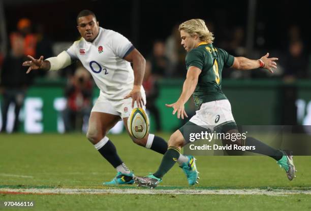 Faf de Klerk of South Africa kicks the ball past Kyle Sinckler during the first test match between South Africa and England at Elllis Park on June 9,...