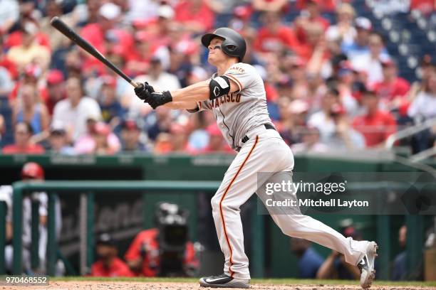 Nick Hundley of the San Francisco Giants hits a three run home run in the third inning during a baseball game against the Washington Nationals at...