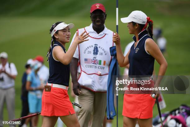 Lucy Li and Andrea Lee of the United States team celebrate on the 16th green against Lily May Humphreys and Shannon McWilliam of the Great Britain...