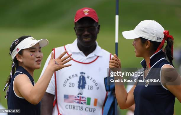 Lucy Li and Andrea Lee of the United States team celebrate on the 16th green against Lily May Humphreys and Shannon McWilliam of the Great Britain...