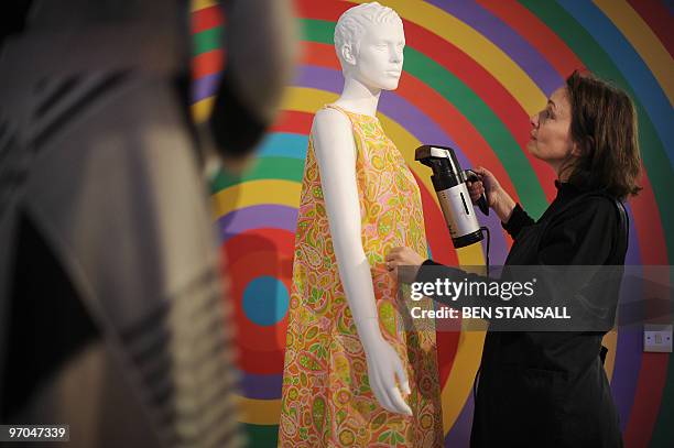 Gallery employee uses a hand steamer on a 1960's dress ahead of the opening of an exhibition entitled 'Carnaby Street: 1960 - 2010' in Carnaby...