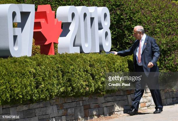 The Organisation for Economic Co-operation and Development Jose Angel Gurria puts a folder down before meeting Canada's Prime Minister Justin Trudeau...
