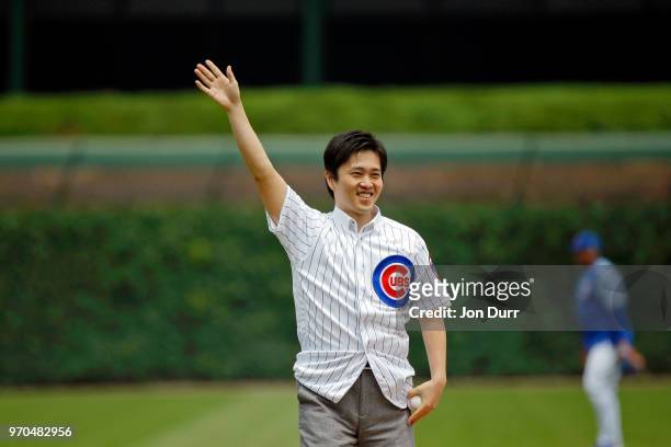 Hirofumi Yoshimura, mayor of Osaka, Japan, acknowledges the crowd before throwing out a cermonial first pitch before the game between the Chicago...