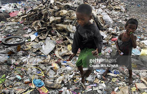 Child stands next to a pile of cow skulls and other food waste materials in a dumping site in the industrial district of Tondo in Manila on March 30,...