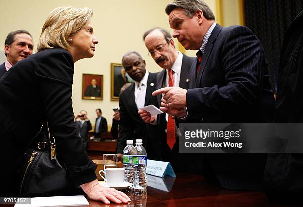 Secretary of State Hillary Rodham Clinton talks to Rep. Chris Smith as Rep. Eliot Engel , and Rep. David Scott look on after a hearing before the...