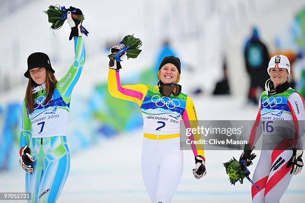 Tina Maze of Slovenia celebrates winning the silver medal, Viktoria Rebensburg of Germany gold and Elisabeth Goergl of Austria bronze during the...