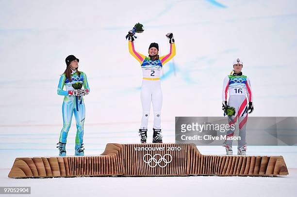 Tina Maze of Slovenia celebrates winning the silver medal, Viktoria Rebensburg of Germany gold and Elisabeth Goergl of Austria bronze during the...