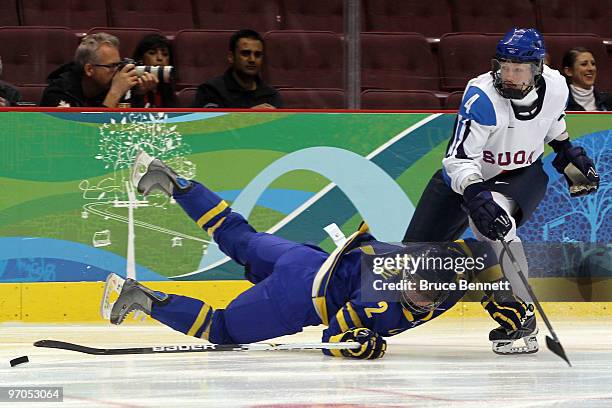 Elin Holmlov of Sweden is hooked by Rosa Lindstedt of Finland during the ice hockey women's bronze medal game between Finland and Sweden on day 14 of...