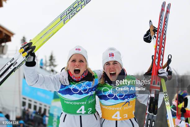 Therese Johaug of Norway and Kristin Stoermer Steira celebrate winning the gold medal during the Ladies' Cross Country 4x5 km Relay on day 14 of the...