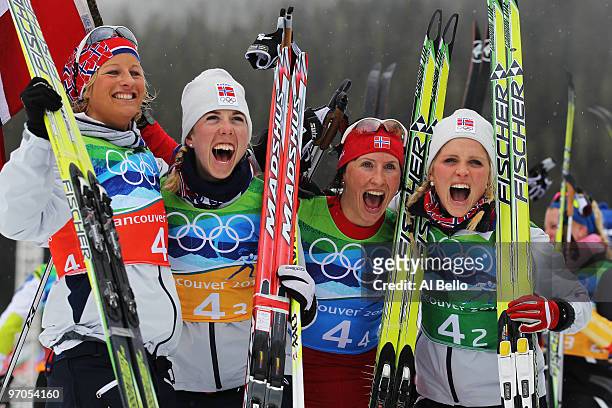 Vibeke W Skofterud, Kristin Stoermer Steira, Marit Bjoergen and Therese Johaug of Norway celebrate after winning the gold medal during the Ladies'...
